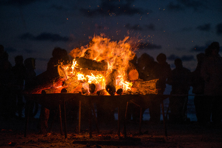 Large burning bonfire with soft glowing flame and sparkles flying all around. Romantic summer...