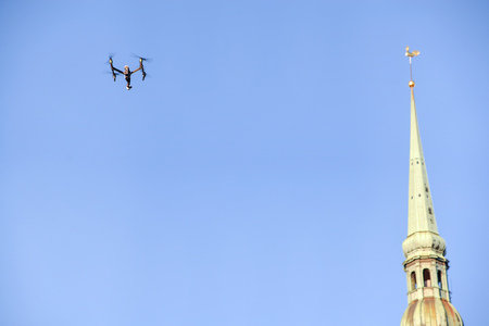 A drone flying over a city next to a Christian churchの写真素材