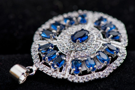 Macro shot of silver pendant with zircon stone and topaz on black background. Beautiful, handmade and expensive jewelry. Meditative, calming, healing and powerful crystalsの写真素材