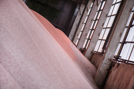 Shot of mixed chemical, artificial nitrogen plant fertilizer granules in factory. Big heaps of...