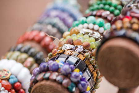 Gemstone bracelets and necklaces in a row. Jewelry made of blue agate crystal, mountain quartz, red coral stones, tiger eye stones. Healing, powerful crystal energy. Esoteric and colorful backgroundの写真素材