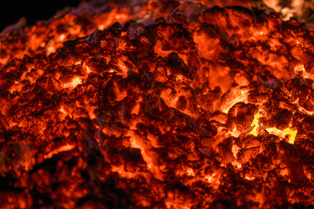 Ignite the fire. Warming up the cold winter nights. A macro shot of firewood and hot, glowing coal. Burning branches and wood. Flames in the fireplace, cozy home, warmth, love, romanticの写真素材