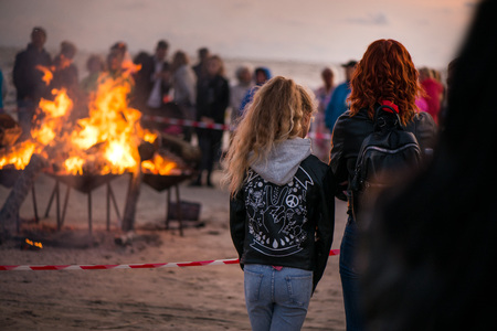 Large burning bonfire with soft glowing flame and sparkles flying all around. Romantic summer evening, people relaxing and enjoying calmness at the seaside during the Night of ancient lights.の写真素材