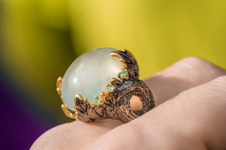 Macro shot of silver engagement ring on colorful, sparkling background. Prehnite stone with emerald. Prehnite is birthstone for zodiac sign of Libra, stone of unconditional love. Healing crystalsの写真素材