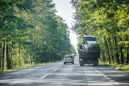 Two crashed cars after accident being transported by tow truck on highway.の写真素材