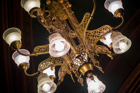 Ancient victorian time chandelier hanging from a ceiling during a masqueradeの写真素材