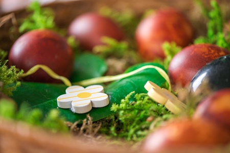 Easter eggs decorated with natural fresh leaves and boiled in onions peels, laying in wicker basket...
