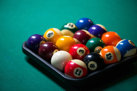 Sport billiard balls set in a box on green billiard table in pub. Players are ready for the round to start the billiard gameの写真素材