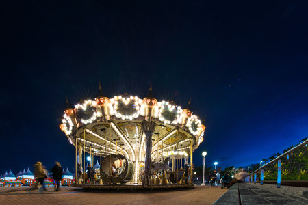 Children's vintage Carousel at an amusement park in the evening and night illumination. Beautiful, bright carousel in Alicante, Spainの写真素材