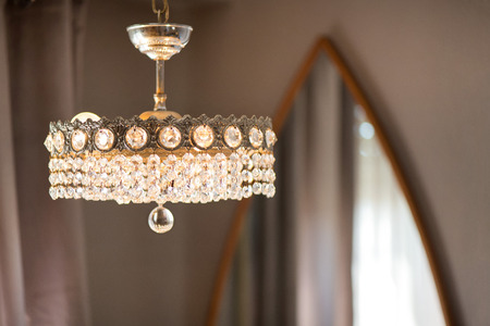Genuine mountain crystal chandelier in a exotic villa dressing room with a huge mirror in the back. Lamp made of diamondsの写真素材