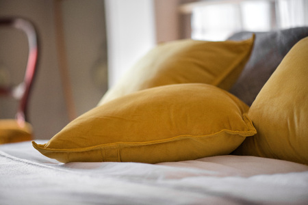 Decorative golden or yellow pillows put on a king size bed to create a welcoming atmosphere for guests. Royal style luxury bedroom.の写真素材