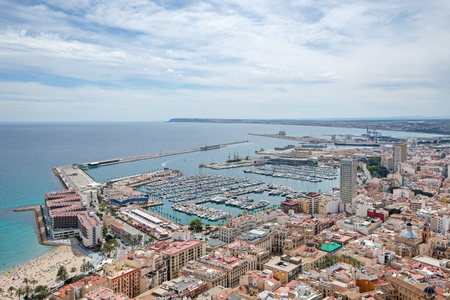 Wide angle view of Alicante, Spain from castle of Santa Barbara. Panoramic view of Postiguet beach, city and harbor. Mixed view of modern city and ruined fortress walls and towers.のeditorial素材