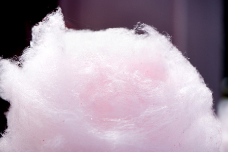 Selling cotton candy. Picking and holding pink cotton candy at a local state fair. Concept of unhealthy eating, too much sugar. Diabetes.の写真素材