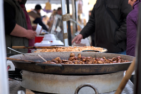 Street food being made in state fair. Traditional meat and sausages grilled in open air market for people. First barbecue party outdoors in springの写真素材
