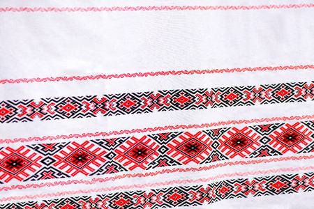 Traditional, natural, rustic linen tablecloth or towel with embroidered flowers and ornaments at local market at state fairの写真素材