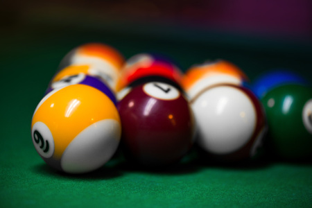 Sport billiard balls set arranged in shape of triangle on green billiard table in pub. Players are ready for the first hit of the round to start the billiard game.の写真素材