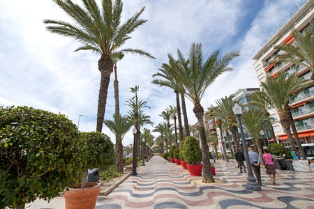 Alley of palm trees is the main tourist street Alicante, Spain, alongside the mediterranean sea. Small market, people are selling hand made souvenirs on street. Beautiful sunny summer eveningのeditorial素材