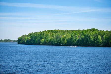 Beautiful, calming nature landscape of lake or river. Green forest on the coastline. Concept of recreation, relaxation and meditation in nature.の写真素材