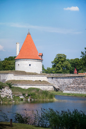Medieval castle in Kuresaare, Saaremaa, Estonia. Fortress next to lake or river. Protection from invaders. Watchtower with red tile roofの写真素材