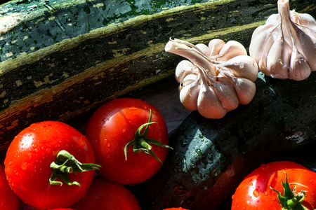 Ripe fresh harvested vegetables on table. Cutting tomatoes, garlic, zucchini, cabbage on wooden board. Making delicious vegetarian meal or canning veggies for winter in jars. Concept of healthy eatingの写真素材