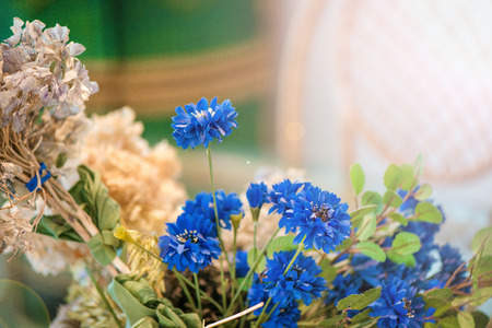 Dried blue flowers and wheat, wicker chairs in dining room with big glass table and decorations.の写真素材
