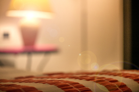 A king sized bed prepared for a newly wed couple with fresh towels and fresh bed linens. Cosy light...
