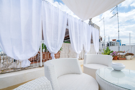 Rooftop terrace prepared for a baby shower. White and bright design to represent innocence and newlife. Beautiful patio with herbs and plants. Cactus in the backgroundの写真素材
