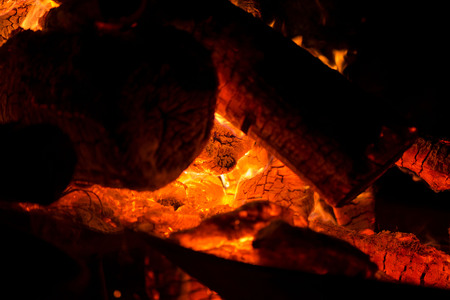 Ignite the fire. Warming up the cold winter nights. A macro shot of firewood, white dust and hot, glowing coal. Burning branches and wood. Flames in the fireplace, cozy home, warmth, love, romanticの写真素材