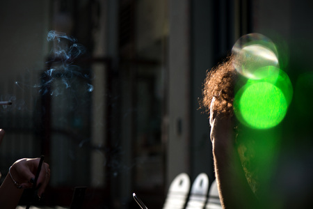 Minors smoking in a public venue, discussing the regulation of tobacco and other psychedelic substances. Smokers causing second hand smoking. Concept of unhealthy habits and living. Having discussionの写真素材