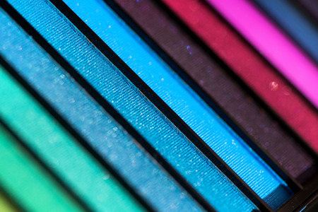 Top, up view of professional cosmetics, makeup background. Brushes and colorful palette of eye...