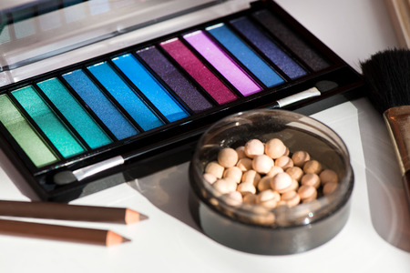 Top, up view of professional cosmetics, makeup background. Brushes, eye shadows, eyebrow pencils,...