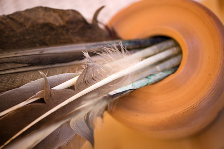 Feather pen in clay inkwell. Medieval, vintage, retro background.  writing with old quill pen on the old paper. Historical atmosphere. Writing calligraphy on reenactment festival in summer in Romania.の写真素材