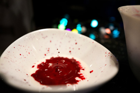 Woman is cooking in kitchen, baking a red velvet cake. Using red food coloring in milk for dough. Concept of unnatural and unhealthy foodの写真素材