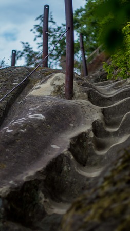 The old stone steps on a hill rising on either side grass.の写真素材