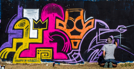 Guy draws graffiti on city streetの写真素材