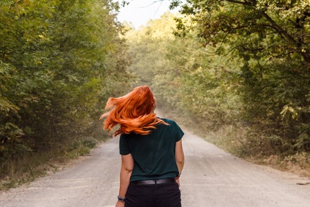 girl on the road dissolve red hair in green forest aloneの写真素材