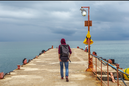 Traveler on the edge of a cliff in the seaの写真素材