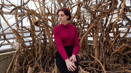 girl in a red shirt and skirt against the background of treesの写真素材
