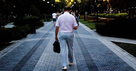 the man is coming from hard work, the view from the backの写真素材