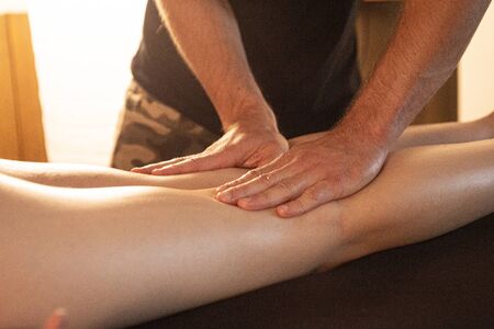 masseur massages the legs of a girlの写真素材