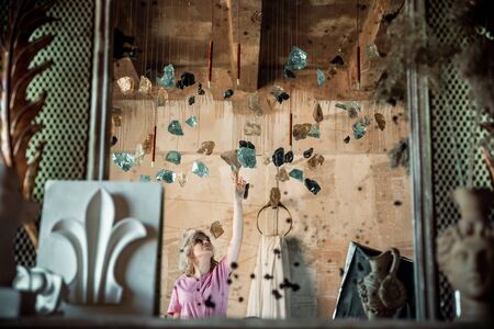Portrait of tender gentle cute lovely sweet pretty charming girl holding bottom of dotted dress with naked shoulders looking up confetti rain isolated backgroundの写真素材