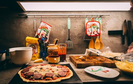 Closeup hand of chef baker in white uniform making pizza at kitchenの写真素材