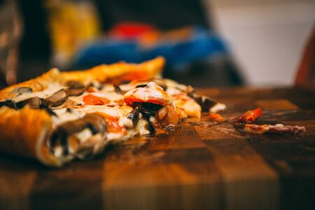 selective focus of italian pizza, spices in grinders, bottle and glass of wine on tabletopの写真素材