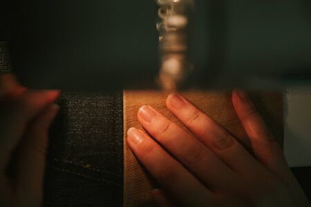 Old sewing machine with black thread scissors and needle, on a old grungy work table.の写真素材