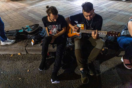 London, UK - August, 2019. Street musician playing a guitar during a performance