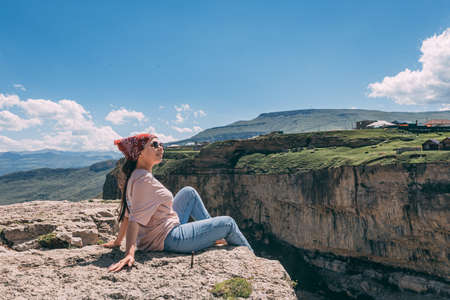 Beautiful girl posing on rocks near the water.の写真素材