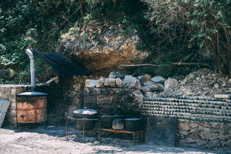 The fire in the old traditional dagestan village oven in a rustic style. Pot of soup near the burning woodの写真素材
