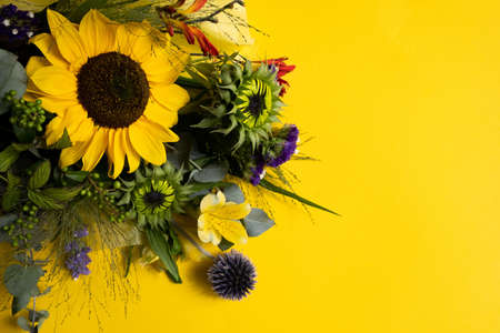 Bright yellow sunflowers on natural rustic texture wooden board. Mockup banner with flowers of the sunflower on dark background with copy space. Autumn harvest, abundance, natural products conceptの写真素材