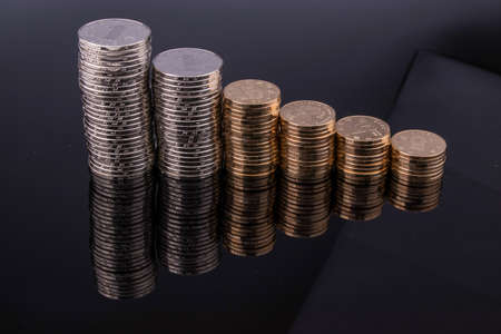 Coins are stacked in layers arranged from small to large. Stacking coins on white background, Money growing concept.の写真素材