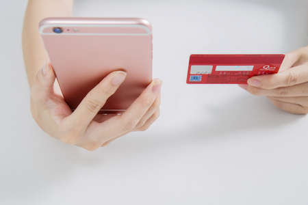 A Handheld Credit Card Knocking In Front Of A Notebook